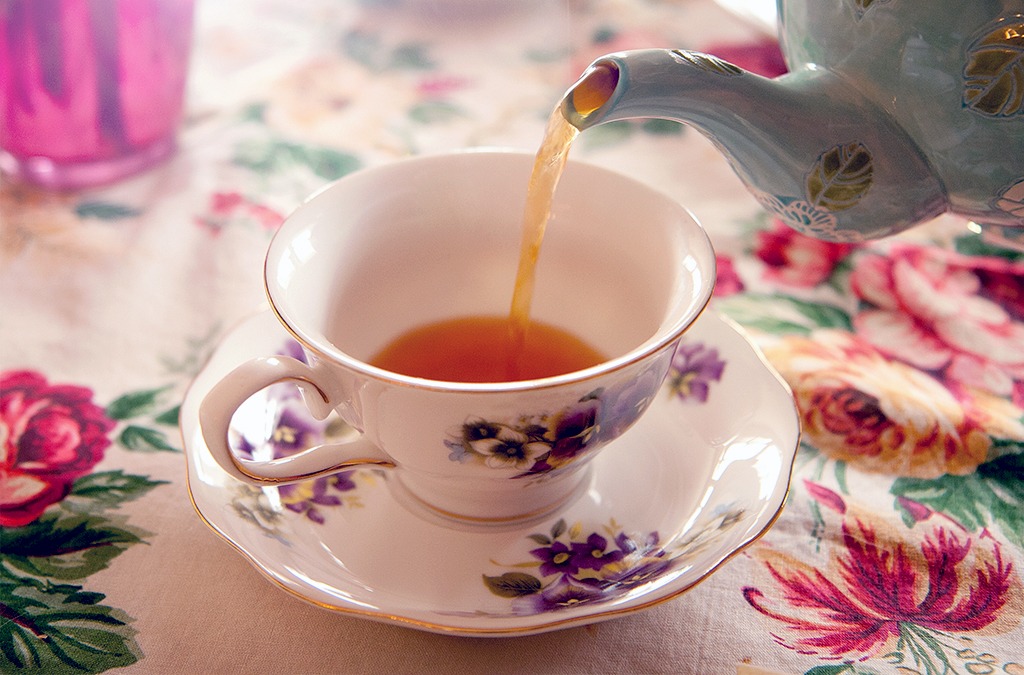 pouring tea into elegant tea cup