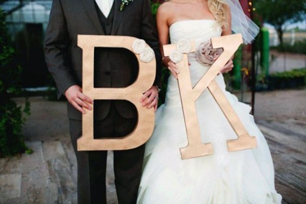 bride and groom holding large wooden initials