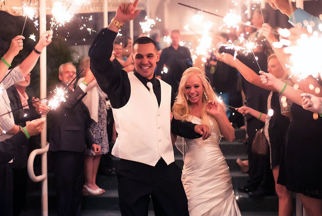 Bride and groom after ceremony and guest with sparklers