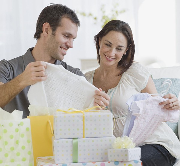 couple opening baby shower gifts