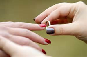 woman putting a ring on her bride