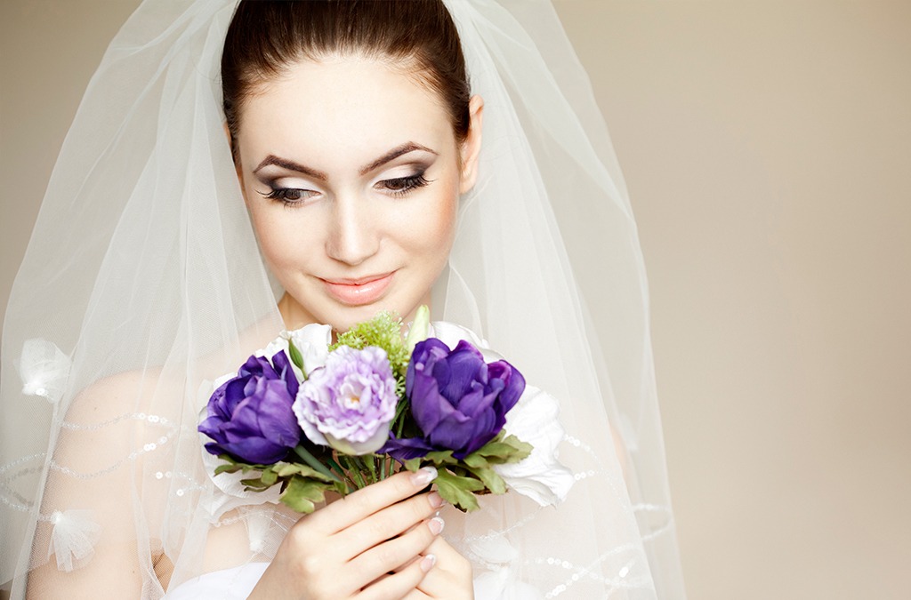 Bride holding purple flower bouquet