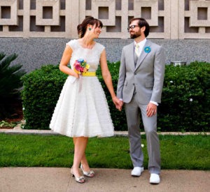 Bride in retro dress holding hands with groom