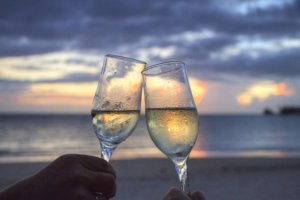 couple drinking champagne on the beach