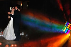 bride and groom dancing in multi-colored outdoor lighting