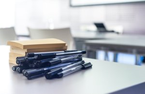 pens and paper on desk for event planning