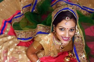 Indian bride dressed in gold, blue and red hues