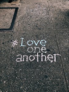 sidewalk chalk that reads hashtag love one another