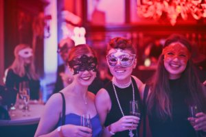 Three young women at a masquerade ball