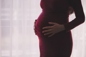 Maternity photo of woman in a red dress