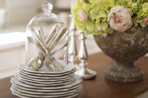 A stack of vintage dishes and cutlery.