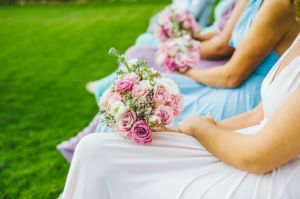 bridesmaids sitting down with flowers in their laps