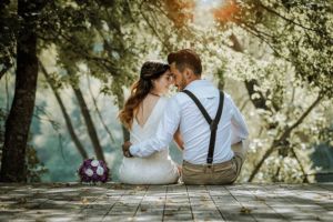 wedding couple sitting on dock 