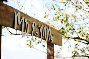 Mr. and Mrs. sign hung outdoors at a wedding celebration