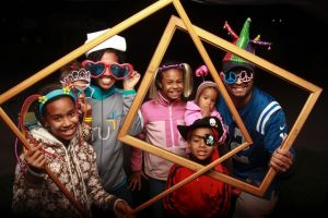 Family posing with photo frames and props at a party photo booth