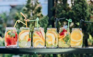 Summer beverages in glass ball jars with colorful fruit and straws