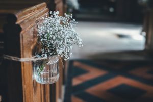 White flowers in a glass vase lining the aisle