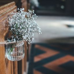 White flowers in a glass vase lining the aisle