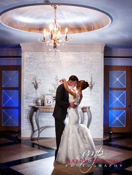 bride and groom under an elegant chandelier at Pinecrest Country Club, a wedding venue near Philadelphia
