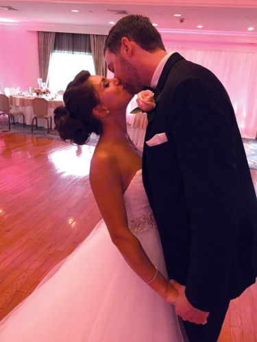 bride and groom in a banquet hall with pink uplighting at Pinecrest Country Club a party space in Montgomery County PA 