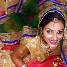 Indian bride dressed in gold, blue and red hues