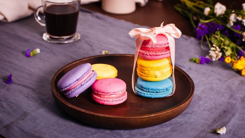 stack of three delicate, colorful macarons tied with a ribbon