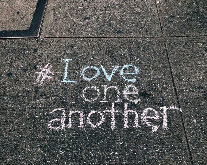 sidewalk chalk that reads hashtag love one another