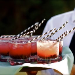 a party tray of cocktails with straws