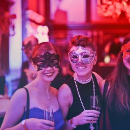 Three young women at a masquerade ball