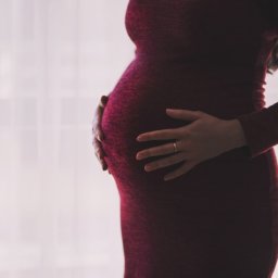 Maternity photo of woman in a red dress