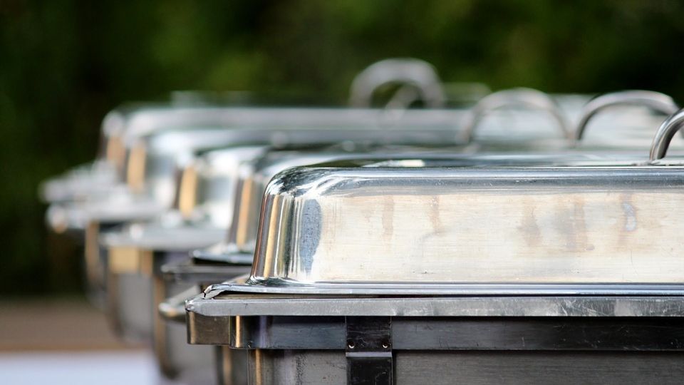 several chafing dishes lined up for a wedding buffet