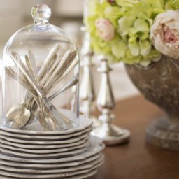 A stack of vintage dishes and cutlery.