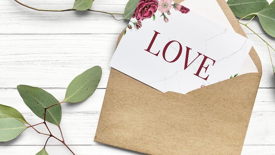 envelop containing a wedding invitation that says Love