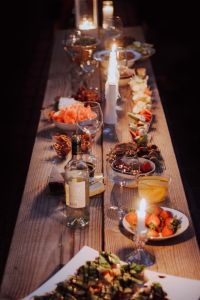 A long wooden table with plates of food and decor on it