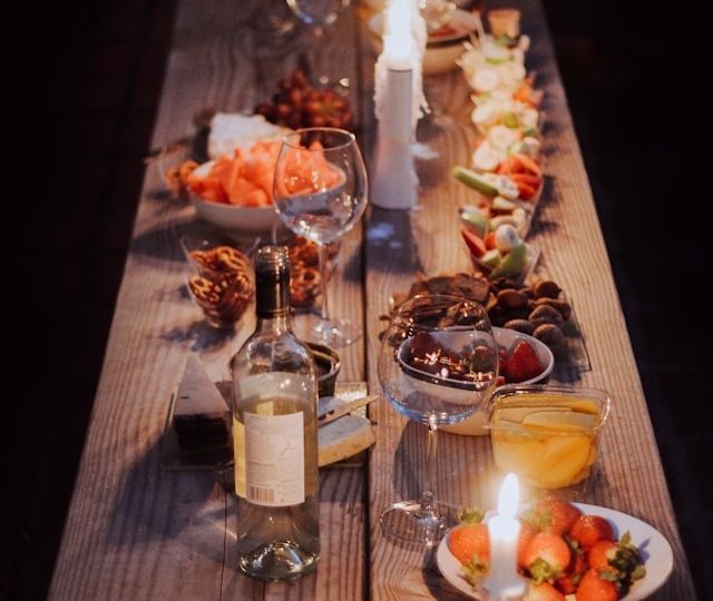 A long wooden table with plates of food and decor on it