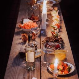 A long wooden table with plates of food and decor on it