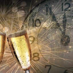 two champagne glasses, fireworks, and a clock