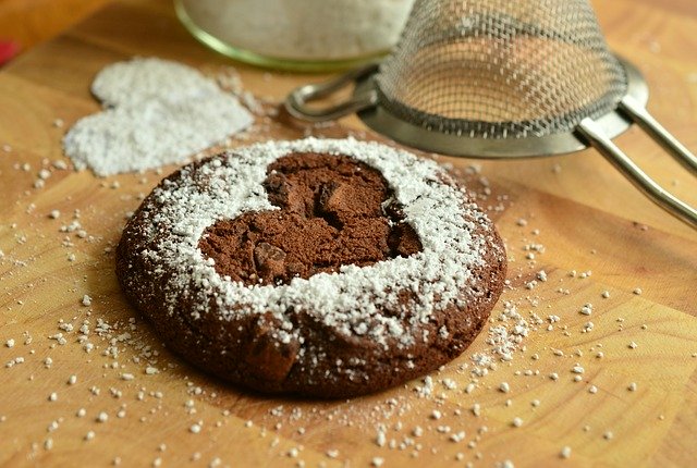 single cookie pastry with a heart imprint and powdered sugar