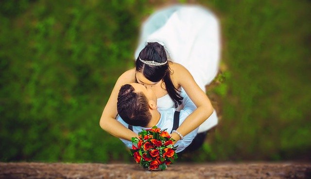 wedding couple embrace with a kiss
