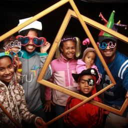 Family posing with photo frames and props at a party photo booth