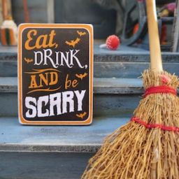 Broom and sign that says eat drink and be scary