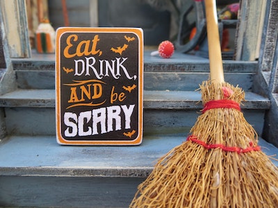 Broom and sign that says eat drink and be scary