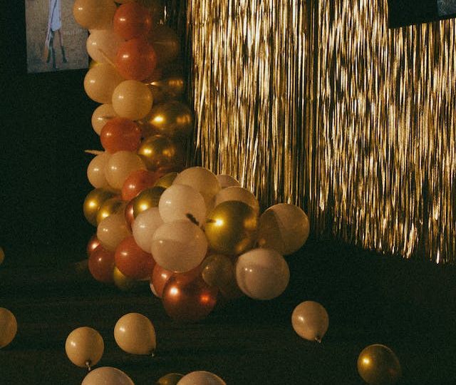 Room decorated with gold tinsel and balloons