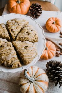 Pumpkin and acorn table decorations with dessert on a white plate