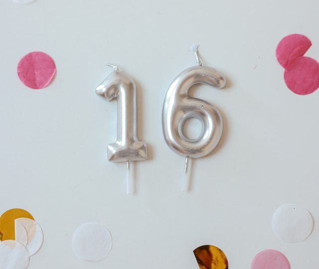 Balloons of the number 16 on a wall.