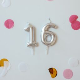 Balloons of the number 16 on a wall.