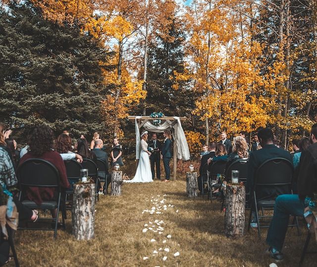 A couple getting married outdoors in autumn