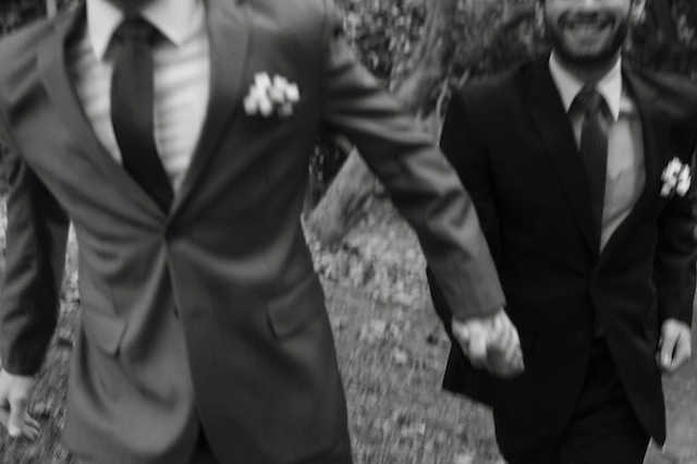 Two grooms holding hands on their wedding day.