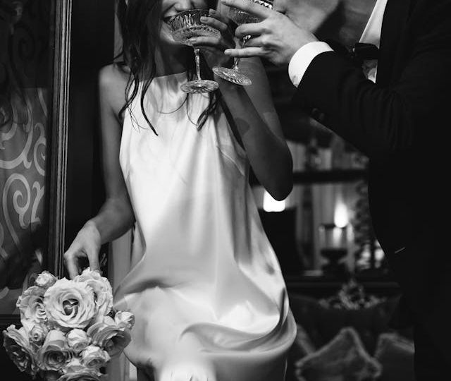 Modern bride and groom drinking champagne