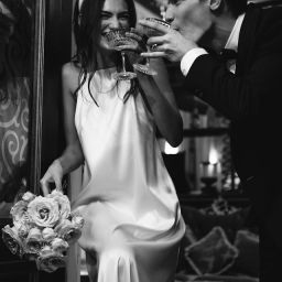 Modern bride and groom drinking champagne